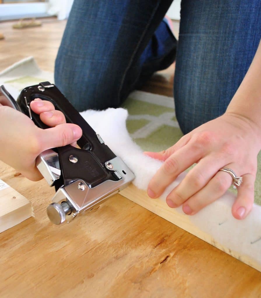 Using staple gun to attach batting to back of DIY upholstered fabric headboard