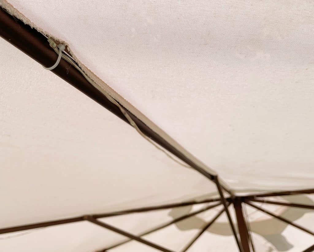 Underside View Of Patio Umbrella With LED Solar Lights Attached With Zip Tie