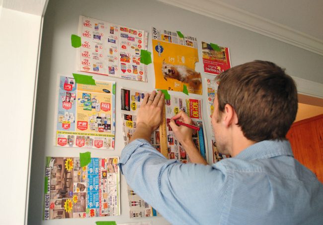 John marking placement of gallery wall using paper templates