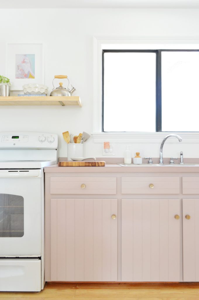 Old cabinets painted Artsy Pink with mauve laminate counters and white stove