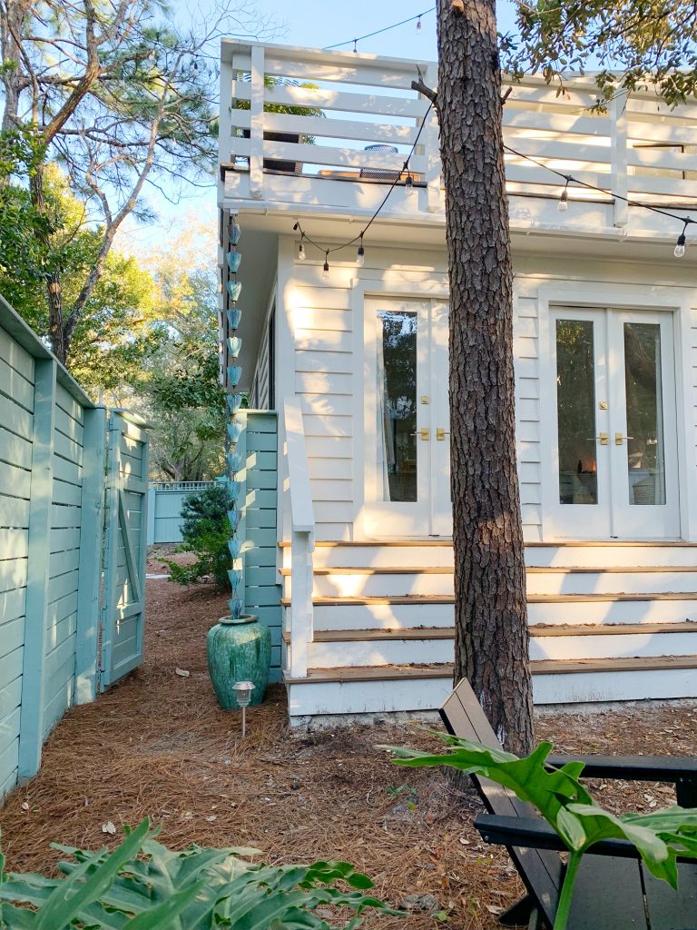 Side gate open next to bedroom stairs allowing access out of fenced side yard