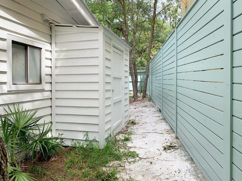 Small white shed attached to side of white house