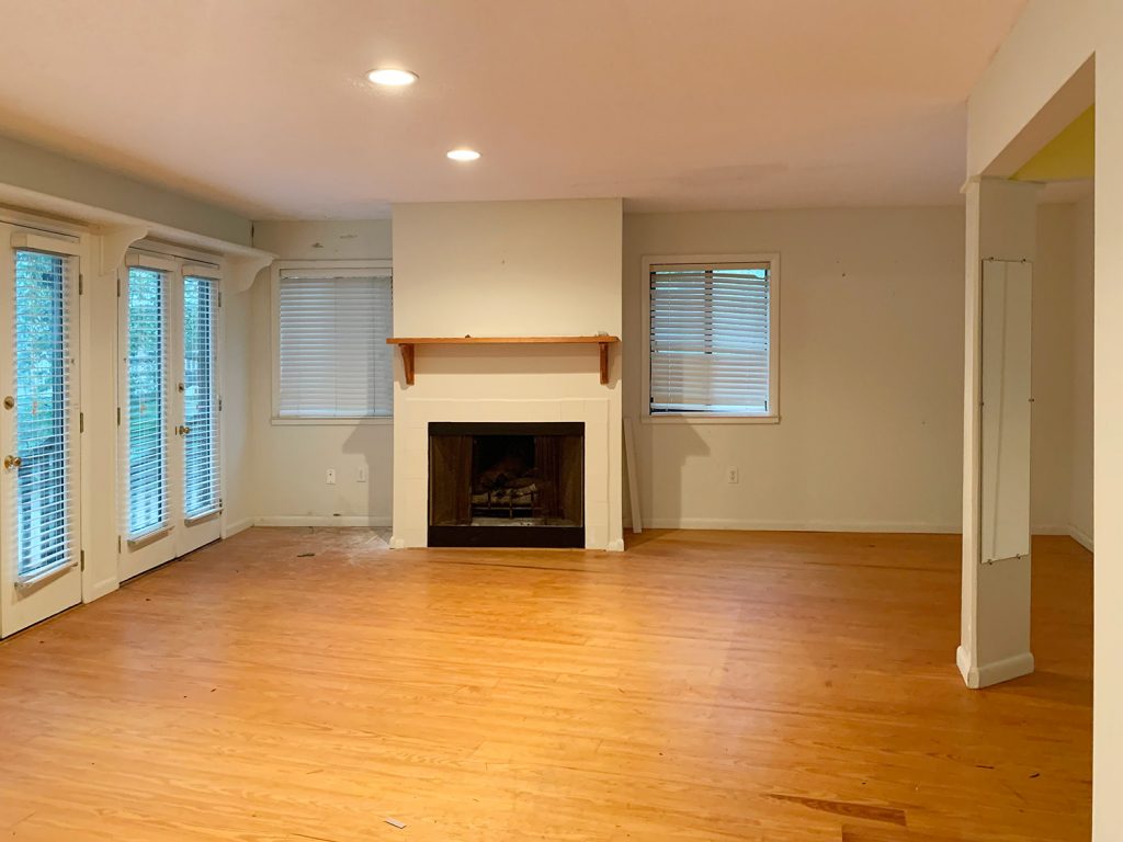 Before photo of bedroom with fireplace and blinds on windows